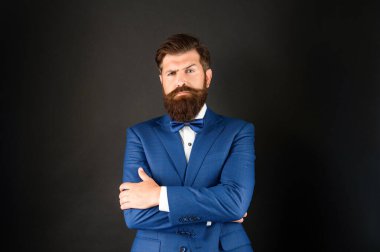 Smokinli papyonlu ciddi sakallı adam. Siyah arka planda resmi giyinmiş gelin damadı. erkek resmi moda.