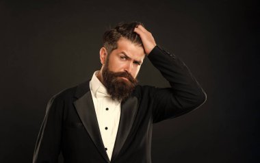 Siyah arka planda smokin giyen sakallı damat, modacı..