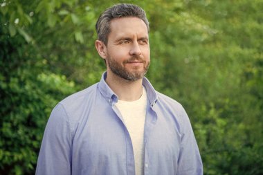 Portrait of handsome professional guy in blue shirt natural background.