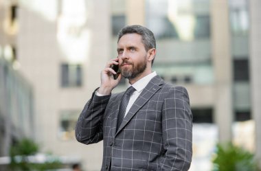 Telefonu olan iş adamı konuşuyor. İş adamının telefon görüşmesi. İş adamı telefonda konuşuyor. İş adamının telefon görüşmesi.