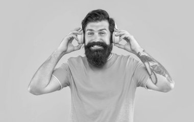 Kulaklık takan havalı bir adamın stüdyo çekimi. Müzik dinliyordum. Modern erkek aleti. Sarıda izole edilmiş kulaklıkla müzik dinleyen havalı adam. Havalı kulaklıklı adam müzik dinliyor..