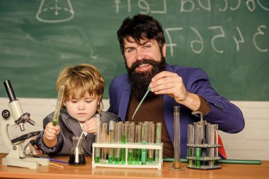 learning chemistry in school laboratory. Back to school. Scientist research and experiments teacher man with little boy. Biology Science lab. father and son at school. We like the element of surprise. clipart