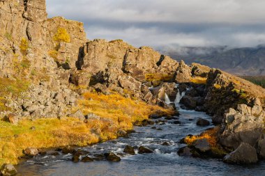 İzlanda 'da nehir kıyısında bir dağ kayalığı. River Creek Şelalesi doğada. Nehir akıyor. Doğal akış. Vahşi doğada akan nehir suyu. Vahşi doğa deresi. Dere suyu deresi. Doğa vahşiliği.
