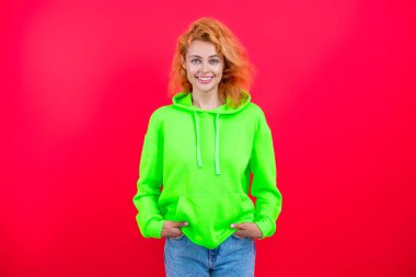 Şık kapüşonlu kızıl saçlı kız. Sıradan kapüşonlu, şık, beyaz bir kadın. Modayla ilgilenen kız modaya uygun ve parlak görünüyor. Pembe kapüşonlu bir kadın. Moda modeli. Sokak kıyafetleri..