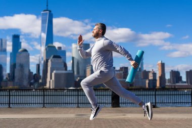 New York 'a doğru koşan sporcu. Sporcu adam aktif giyinmek için koşuyor. Sporcu koşucu. Manhattan 'da spor habercisi. Bir maraton koş..