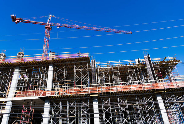 Construction site with building crane. Industrial area. Building and construction. Hoisting crane. Construction building site with crane. Construction crane at building area. Structural engineering.