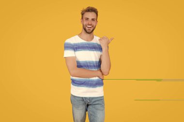 Gülümseyen adam, sarı üzerine izole edilmiş yaz indirimi için heyecanlı görünüyor. İnsanoğlunun yaz indirimi ilanı. Yazlık tişörtlü adam indirim yapıyor. Adam yaz indiriminden yararlanıyor..