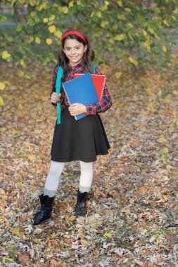 Açık hava okulunda kız eğitimi. Bilgi ve eğitim. Bilgi toplama günü. Sonbaharda okul ödevi yapan kız. Okula dönelim. Sonbahar parkında ödevleri olan genç bir kız. Öğrenci ev ödevi.