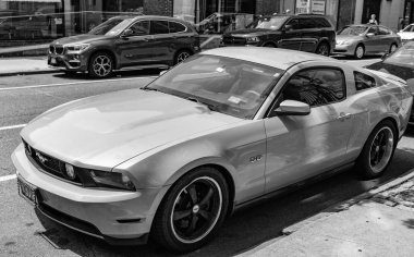 New York, ABD - 05 Ağustos 2023: 2011 Ford Mustang V6 sarı araba ön ve yan görüş, yolun sol tarafında park edilmiş.
