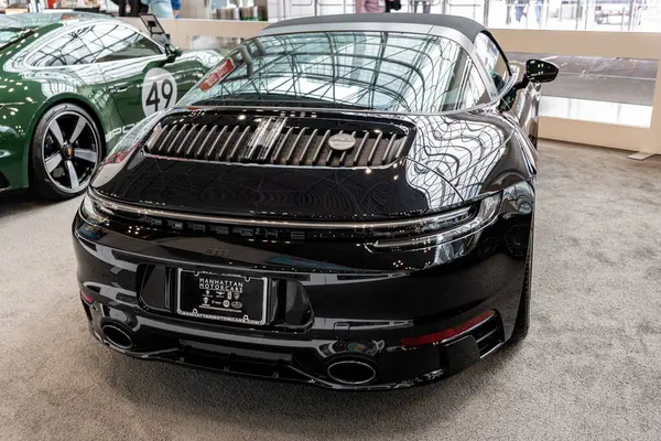 stock image New York City, USA - March 27, 2024: 2023 Porsche 911 convertible. Black Porsche 911. Porsche 911 retro car at New York International Auto Show, back angle view.