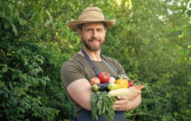man in straw hat hold fresh ripe vegetables.