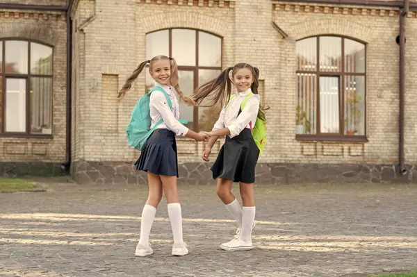 smiling two school girls best friends together outdoor.