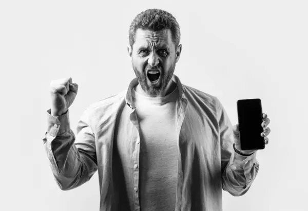 stock image successful man showing phone app isolated on studio background. man showing phone app in studio. showing phone app. photo of man showing phone app.