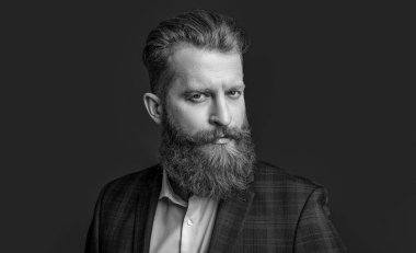 Stüdyoda resmi erkek giyim bölümünde. Arka planda erkek giyim bölümündeki resmi adam. Resmi erkek giyimli sakallı adam fotoğrafı. erkek giyimli resmi adam kırmızıda izole edilmiş..