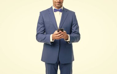 Kırpılmış mavi papyon takım elbiseli adam telefonda sohbet ediyor..