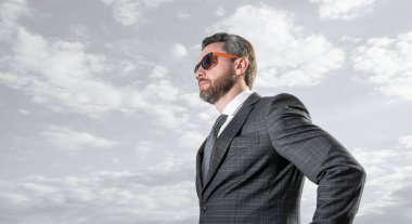 Gökyüzü arka planında fotokopi alanı olan takım elbiseli bir CEO. Dışarıdaki takım elbiseli CEO. Takım elbiseli CEO. Takım elbiseli CEO 'nun fotoğrafı..