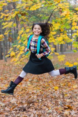 Bilgi ve eğitim. Okul eğitimi. Öğrenci hayatı. Okula dönelim. Sonbahar kızının okul çantası var. Ergenlik için eğitim. Sonbahar parkında açık havada genç bir kız. Çalışmak için sonbahar zamanı. Zıplayan öğrenci.