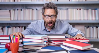 Sınıfın işyerindeki öğretmen. İspanyol öğretmen bilgisini ve eğitimini paylaşıyor. Sınıfta öğretmenlik dersi. Okulda öğretmenler sınıfı. Okula dönüyorum. Kitap yığını.