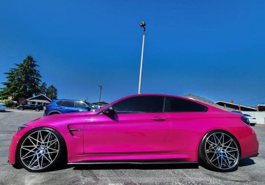 Seattle, WA, USA -July 19, 2024 : BMW F82 M4 Competition pink color side view. BMW F82 M4 is the sport version of BMW car clipart