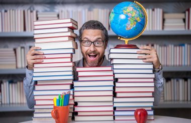 Sınıftaki kitap kurdu adam. Kitap edebiyatı öğretmeni. Okul kütüphanesinde eğitim. Adam kitap kurdu bilgi topluyor. Öğretmenler ve bilgi günü. Zeki öğretmen. Bir dahi gibi düşünüyorsun..