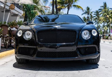 Miami Beach, Florida USA - 9 Haziran 2024 Bentley Continental GT Miami Beach Ocean Drive Caddesi. Siyah Bentley Continental GT okyanus yolunda.