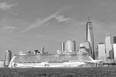 New York, USA - June 13, 2023: Cruise ship Norwegian Joy Sailing next to Manhattan in New York. Skyline of New York Manhattan cruising on the Hudson River cruise liner NCL. clipart