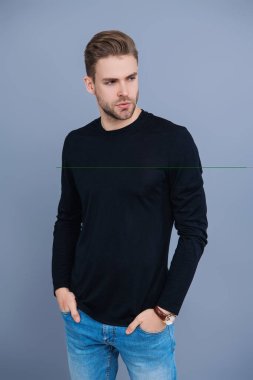 Tıraşsız adam Griler 'de izole edilmiş. Şık saç kesimi olan bir adamın portresi. Milenyum karizmatik modeli. Erkeklerin güzelliği. Kendine güveni olan adam. Gündelik kazak giyen genç yakışıklı bir adam. Kafkas modeli.