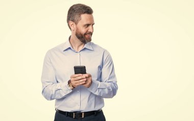 Takım elbiseli bir iş adamı telefon kullanır. Blogda iş adamıyla mesajlaşıyorum. İletişim. Telefondaki mesajlaşan iş adamı beyazdan izole edilmiş. İş mesajlaşması. İnternet işi. Boşluk afişini kopyala.