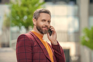 Pozitif adamın dışarıda cep telefonu görüşmesi var. Sokakta cep telefonu arayan bir adam var. Dışarıdaki cep telefonundan arayan bir adam. Adamın cep telefonuyla arayıp konuştuğu bir fotoğraf..