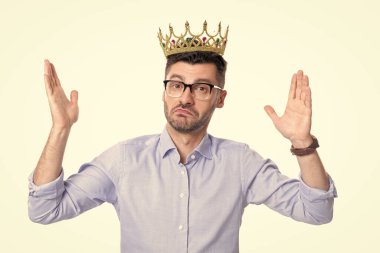Taç giymiş bencil iş adamı. Taç giymiş bencil iş adamının stüdyo fotoğrafı. Beyaz arka planda soyutlanmış, taç giyen bencil iş adamı. İş adamına taç ödülü. Bencillik kavramı.