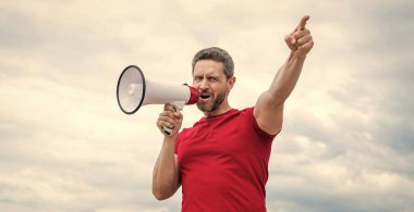 Kırmızı gömlekli adam arka planda hoparlörden bağır. ajitasyon.