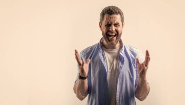 Hayal kırıklığına uğramış bir adam stüdyo ve fotokopi odasında hayal kırıklığını ifade eder. Hayal kırıklığına uğramış bir adamın bağırışının fotoğrafı. Gömlek giyen bir adamın hüsranı. Hayal kırıklığına uğramış bir adam gri arka planda izole edilmiş..