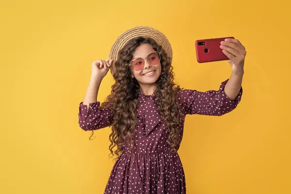 stock image glad girl with curly hair taking selfie on phone.