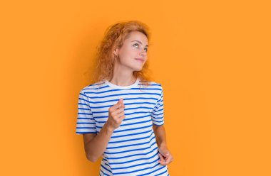 Kızıl saçlı kadın sarı arka planda izole bir şekilde eğleniyor. Stüdyodaki genç kızıl saçlı kadının portresi. Yetişkin kızıl kadın portresi.