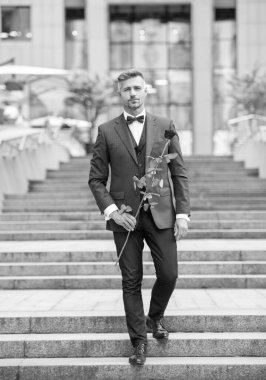 Smokinli şık bir adam. Smokin giymiş, papyonlu bir adam. Kırmızı güllü yakışıklı smokinli adam..