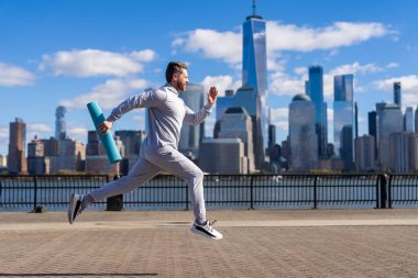 New York 'ta sabah sporu koşucusu. Spor antrenmanında koşan koşucu. Sporcu koşucu ya da koşucu. Spor takım elbiseli bir adam koşu yapıyor. Manhattan 'da koşan adam. Fiziksel uygunluk.