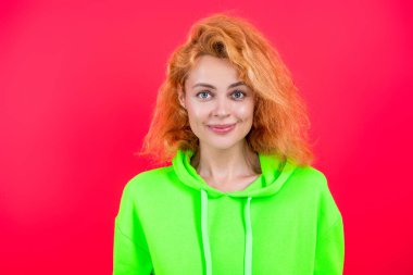 Moda kıyafetleri ve tarzı. Kazaklı beyaz bir kadın. Sıradan bir yaşam tarzı. Havalı kapüşonlu giyen kızıl saçlı kız. Pembe üzerine izole edilmiş şık bir kadın. Hareketli moda kız kapüşonlu giyer. Boşluğu kopyala.