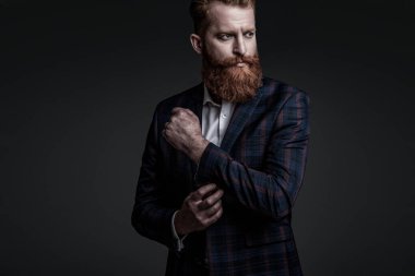 Özel dikim erkek giysisi giymiş sakallı adam. Özel dikim kıyafet giyen bir iş adamı. Şık takım elbiseli bir iş adamı. Resmi terzilik kıyafeti. Erkek giyim kuşamı. Bespoke takımı..