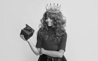 Sarı arka planda mevcut kutusuyla taç giymiş mutlu bir çocuk..