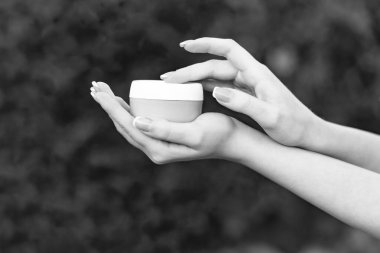 hands holding and applying cream jar for skincare. cosmetology.