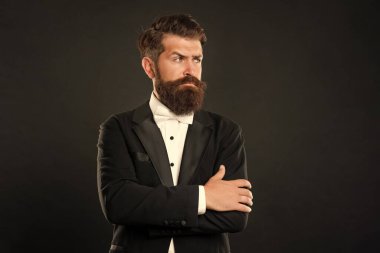 bearded bridegroom in tuxedo on black background, fashionist.