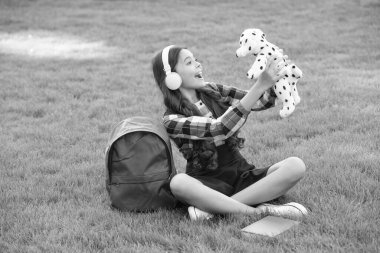 Genç kız şarkı söylüyor, okuldan sonra çimlerin üzerinde köpek oyuncağı tutuyor, müzik çalıyor. Okula dönüyorum. Okul zamanı öğrenci..