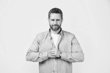 Stüdyoda sakalı olan neşeli, olgun bir adam. Sakallı, olgun bir adamın fotoğrafı. Kirli sakallı, normal gömlekli olgun bir adam. Gri arka planda sakallı, olgun bir adam..