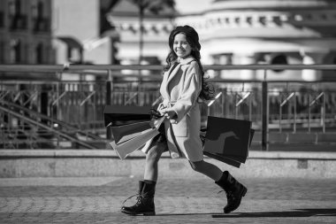 Genç kız gardırobu yeniledi. Sonbahar indirimi ve indirim. Açık havada alışveriş yapan genç bir kız. Alışverişçi kız için sonbahar modası. Sonbahar alışverişi. Sonbahar moda kızı için modaya uygun kıyafetler. Alışveriş yoluyla iyileşme.