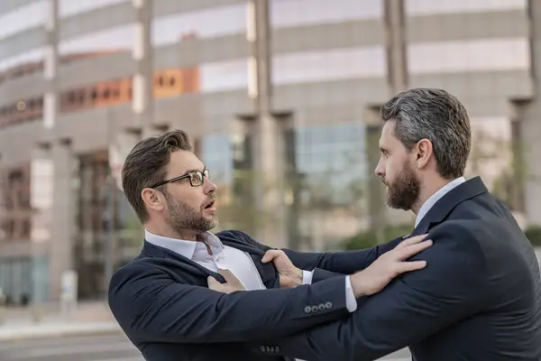 stock image Businessmen having conflict in business. Conflict between boss and employee. Fight aggression. Angry businessmen. Business conflict. Two businessmen conflicting at fight outdoor. Anger management.