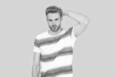 Sarı arka planda izole edilmiş sakallı genç adam. Şık bir stüdyo resmi. Bin yıllık insan portresi. Yakışıklı bir adam kameraya bakarak bir portre için poz verir..