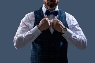 Zarif siyah takım elbiseli şık bir adam. Smokinli bir beyefendi. Resmi etkinlikteki iş adamı. Damadın smokin tarzı var. Centilmen smokini. Smokin, kesilmiş. Papyonlu adam gride izole edilmiş. Smokin Bakımı.