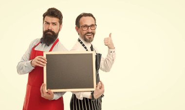 Bartender with blackboard advertisement. Hipster bartender show blackboard copy space. Hiring restaurant staff. Men bearded informing happy hours. Men bearded bartender in apron hold blank chalkboard.