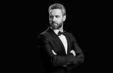 Olgun resmi smokin giyen adam siyah arka planda izole edilmiş. Resmi giyim stüdyosundaki smokin giyen adam. Resmi papyonlu smokinli adam. Resmi takım elbiseli bir smokinlinin fotoğrafı..