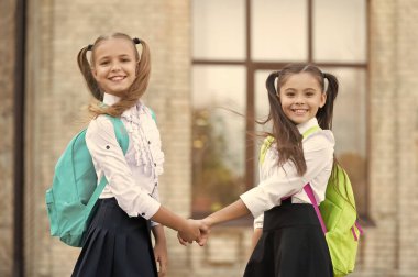 glad two school girls best friends together outdoor.